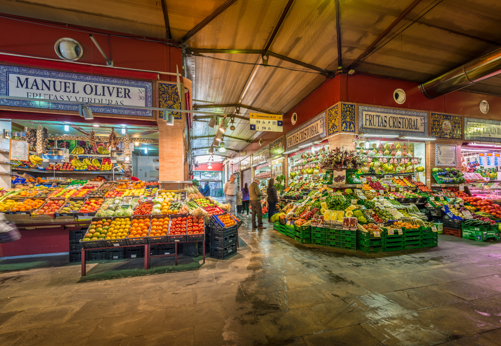 An entrance of a market in Triana, one of the best areas to stay in Seville, where the front stores sells various fruits and vegetables. 
