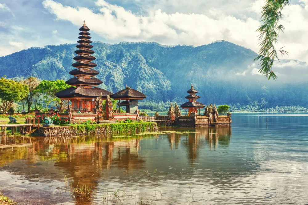 Bali's Pura Ulun Danu Temple shown on a misty morning with mountains in the background for a list ranking the best tourist destinations in the world