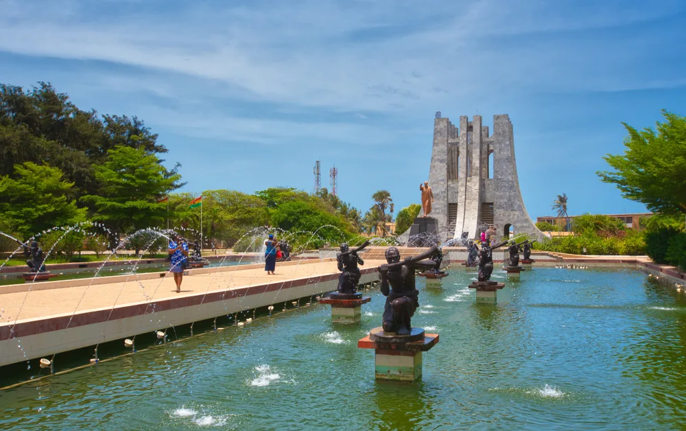 People walking along a cement path with fountains around it for a guide to the average cost of a Ghana trip
