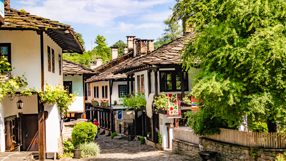 Bulgaria, one of the cheapest places to travel in Europe, shopping street with historical houses in summertime with greenery surrounding the buildings on a sunny day
