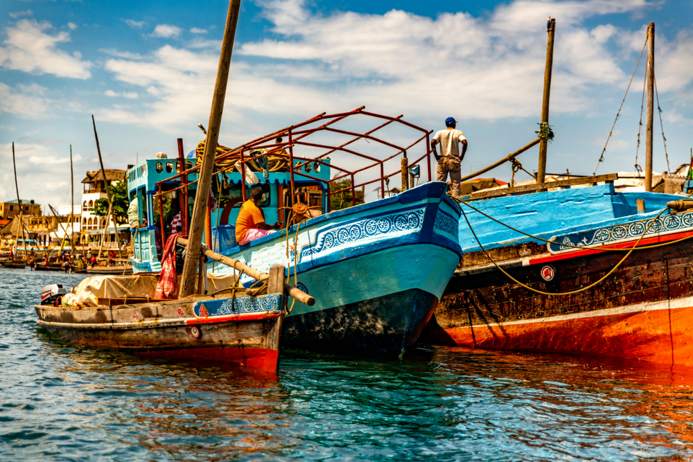 Colorful fishing boats floating on water in a port in Kenya