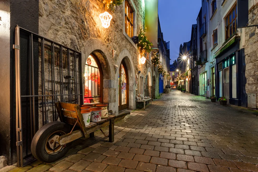 Old street pictured at night in Galway decorated with Christmas lights for a guide titled Is Ireland Safe to Visit