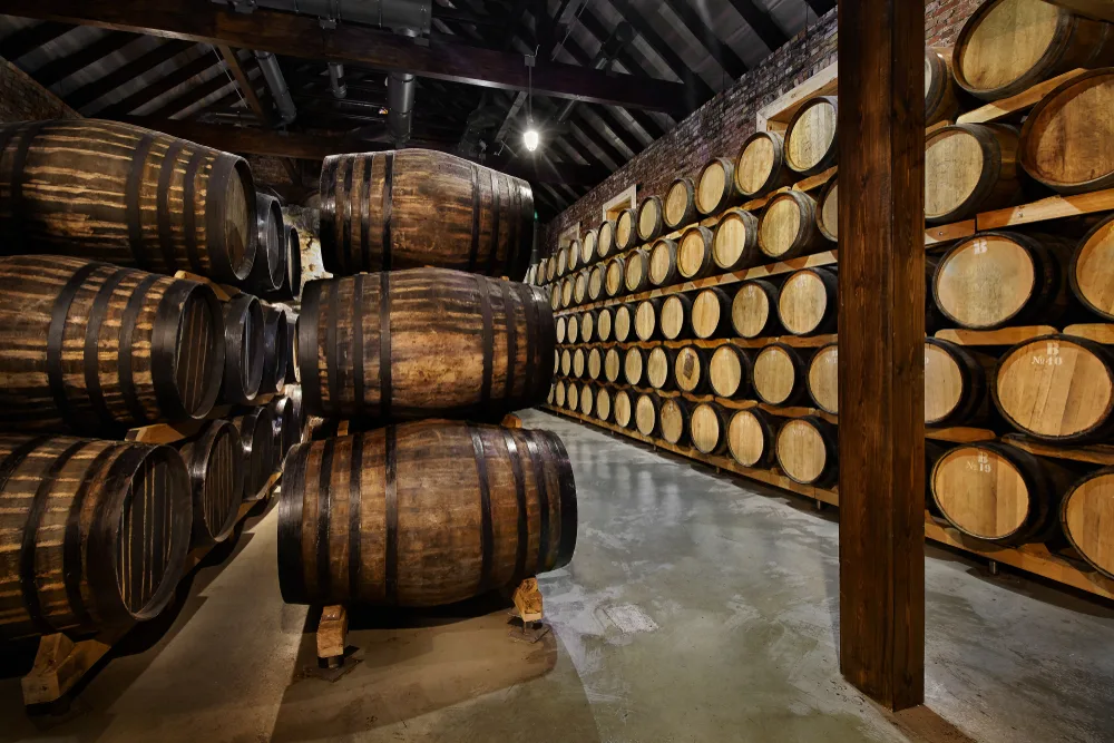 Bourbon barrels stacked up inside a distillery where people can take tours as one of the best guys trip ideas in Louisville, KY