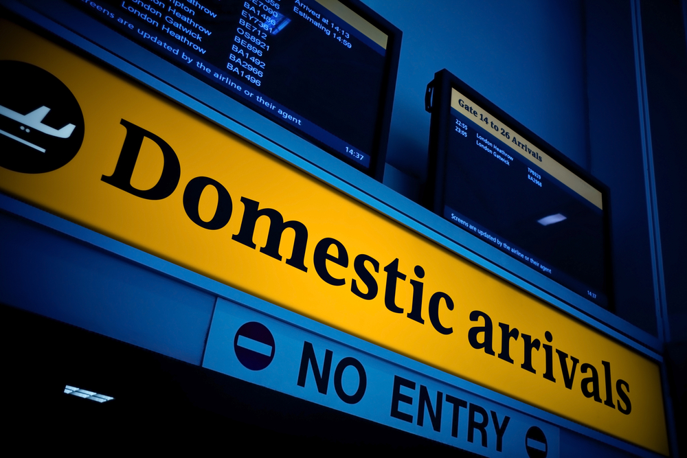 Domestic arrivals illuminated sign in an airport for an article explaining what is domestic travel