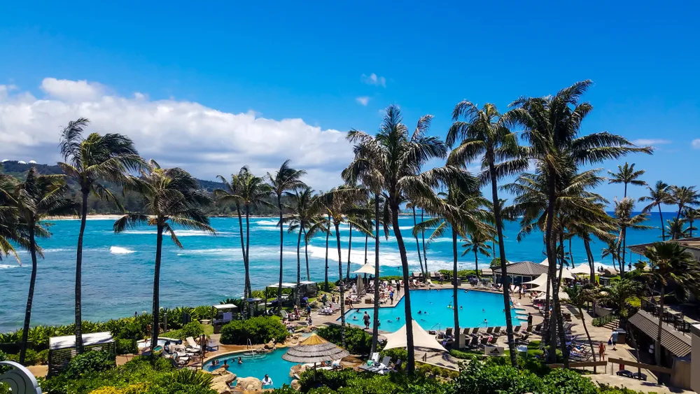 View of the pool area and private beach at Turtle Bay Resort in Oahu, Hawaii which is one of the best all-inclusive vacations no passport needed for US citizens