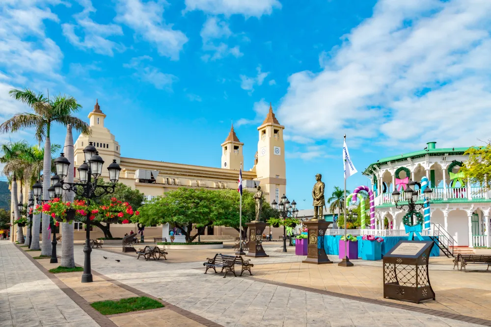 Gorgeous view of the idyllic town of Puerto Plata with its historic terra cotta roofs and a neat circular building next to an open-air town square for a piece titled Where to Stay in the Dominican Republic
