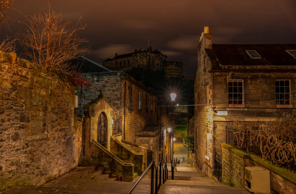 Earie view of Vennel, a street in Edinburgh, pictured at night with its few lights illuminating the narrow alleyway
