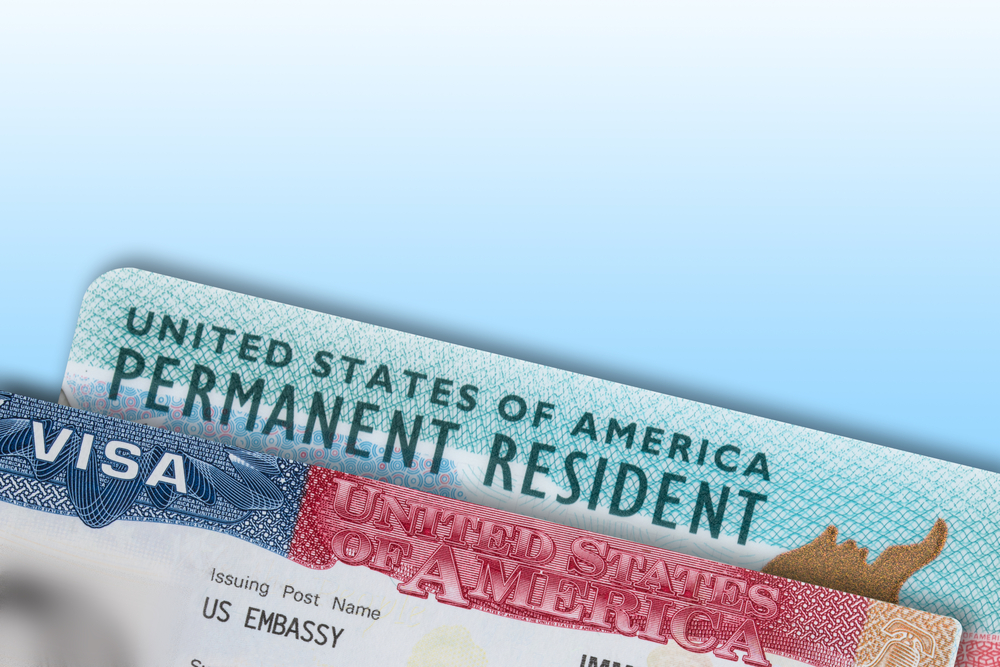 Upper edges of a US Green Card and visa shown with gradient blue background to indicate different types of travel document numbers other than passports