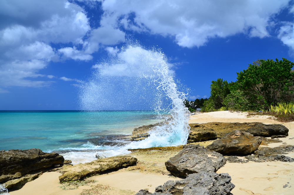 The beach on St. Croix at Frederiksted with water splashing against the rocks onshore for a list of the best places to travel without a passport