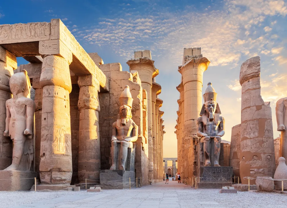 A preserved ruins of gigantic columns and statues during a sunset in Luxor, one of the best areas to stay in Egypt.