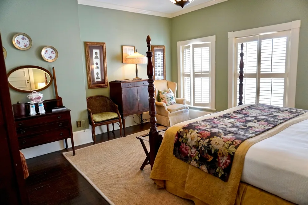 The Ballastone Inn Mary Musgrove room interior with antique furnishings in Savannah, GA to show how inns are different from motels and hotels