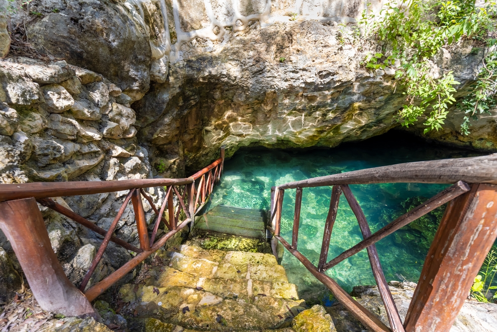 A stone stairs with wooden railings leading down to fresh water spring cave. 