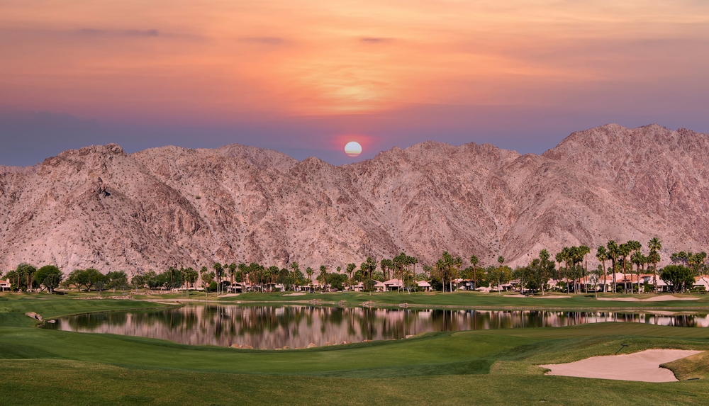 PGA West Golf Course in Palm Springs, CA with snowy mountains in the background at sunset for a list of the best places to visit in the United States during winter