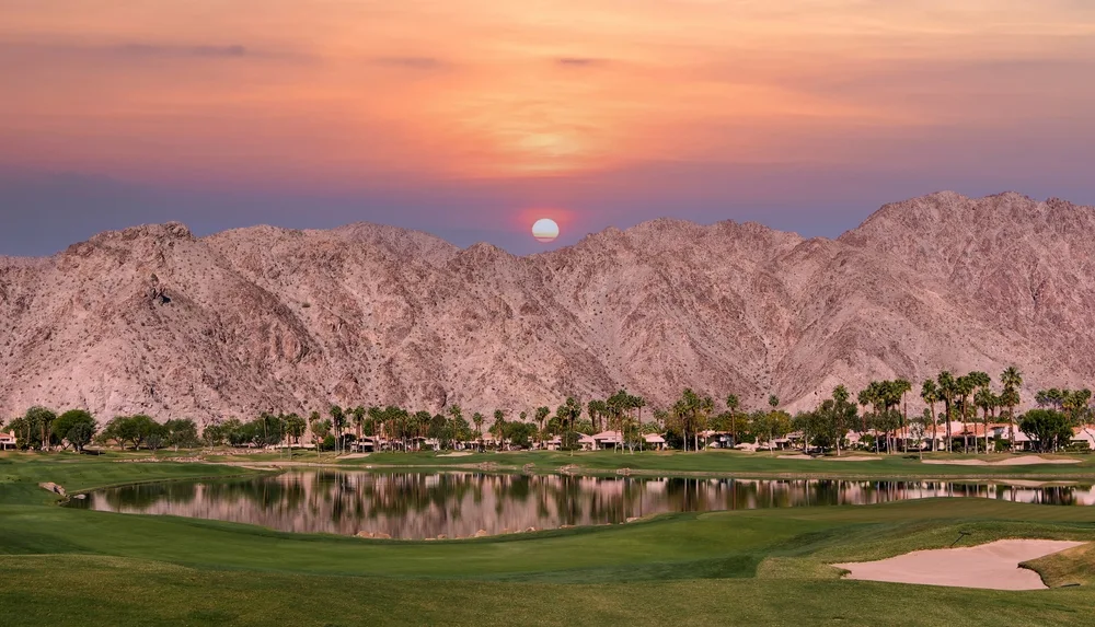 PGA West Golf Course in Palm Springs, CA with snowy mountains in the background at sunset for a list of the best places to visit in the United States during winter