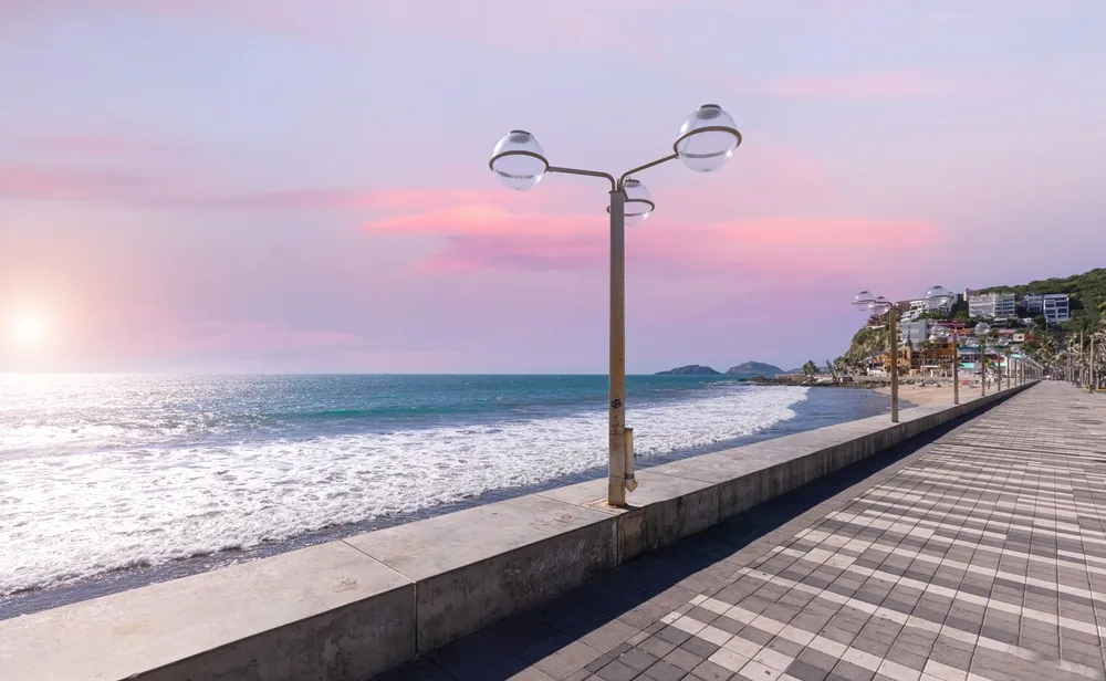 A lovely boardwalk in Malecón with array of street lamps facing the calm beach during a sunset.