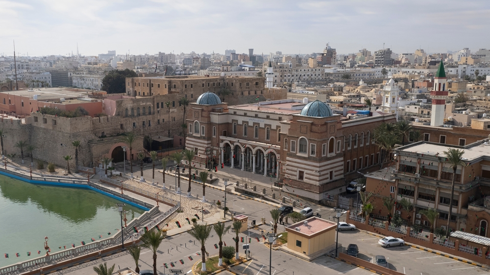 A large structure in front of a bay, and a populated city can be seen in background for a guide titled is the Mediterranean safe to visit