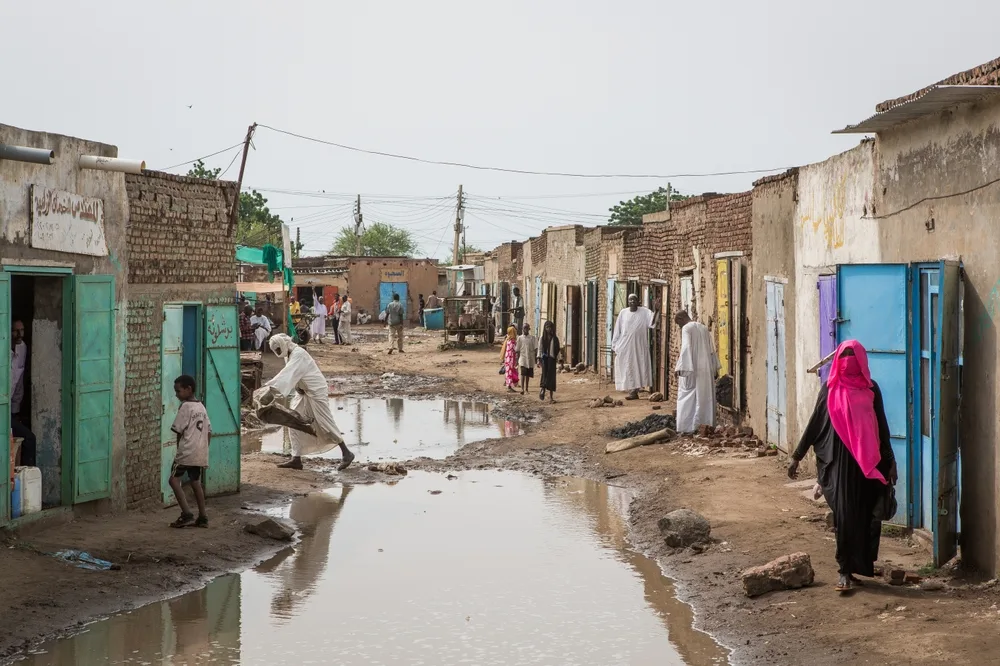 Wet and muddy street in the middle of a village in Sudan pictured during the least busy time to visit, the rainy season