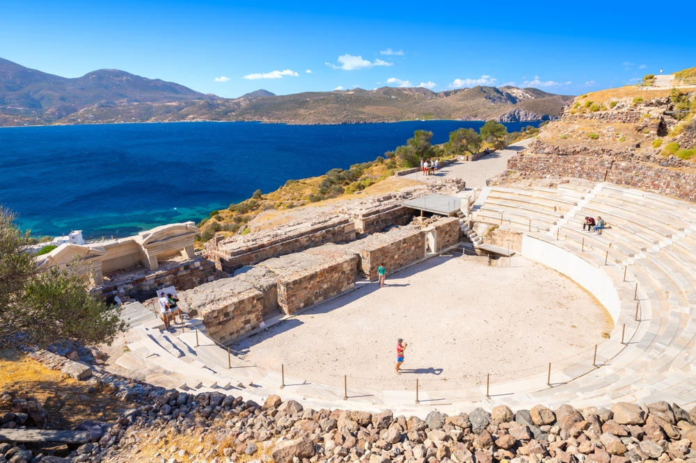 An old amphitheatre in the coastal area with a view on the opposite mountainous island, captured as a section image for travel guide about safety in visiting Milos.