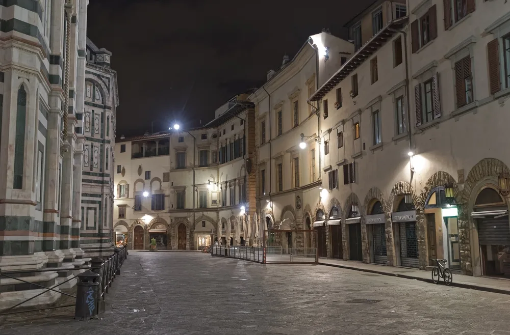 Florence Italy pictured at night with lights illuminating the cobblestone streets