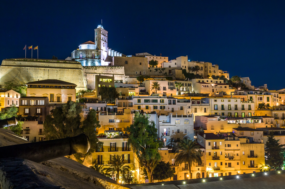Photo of the hillside town of Old Town Ibiza at night for a guide titled Is Ibiza Safe to Visit