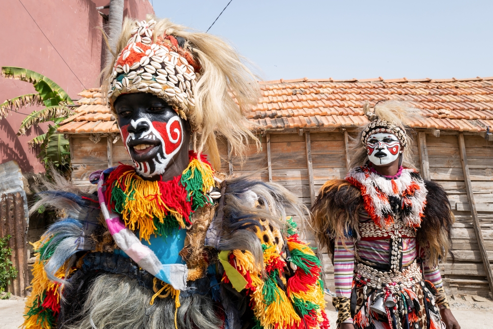 Tribal kids in disguise celebrating a festival during the cheapest time to visit Senegal