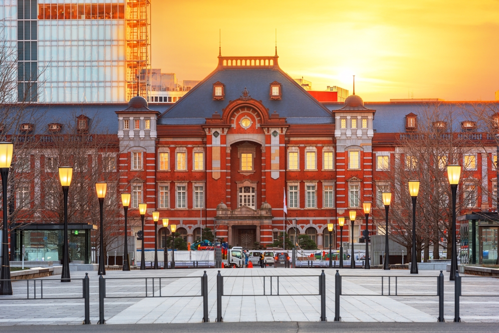 Historic red brick Tokyo Station pictured in front of a gorgeous orange sky in the fall for a guide to the best tourist destinations in the world
