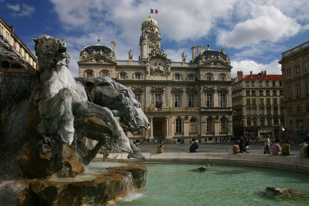 For a guide titled Is Lyon Safe to Visit, a city hall and Place des Terreaux pictured with its majestic fountain in front