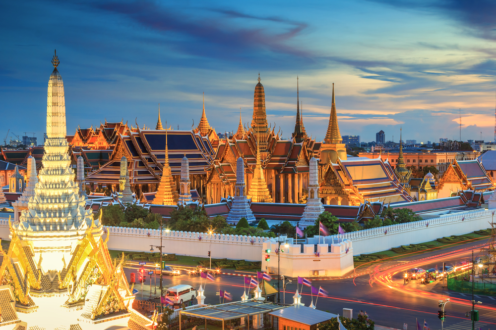 Bangkok, Thailand's Grand Palace and Wat Phra Keaw at sunset shown illuminated as one of the best places for solo travel