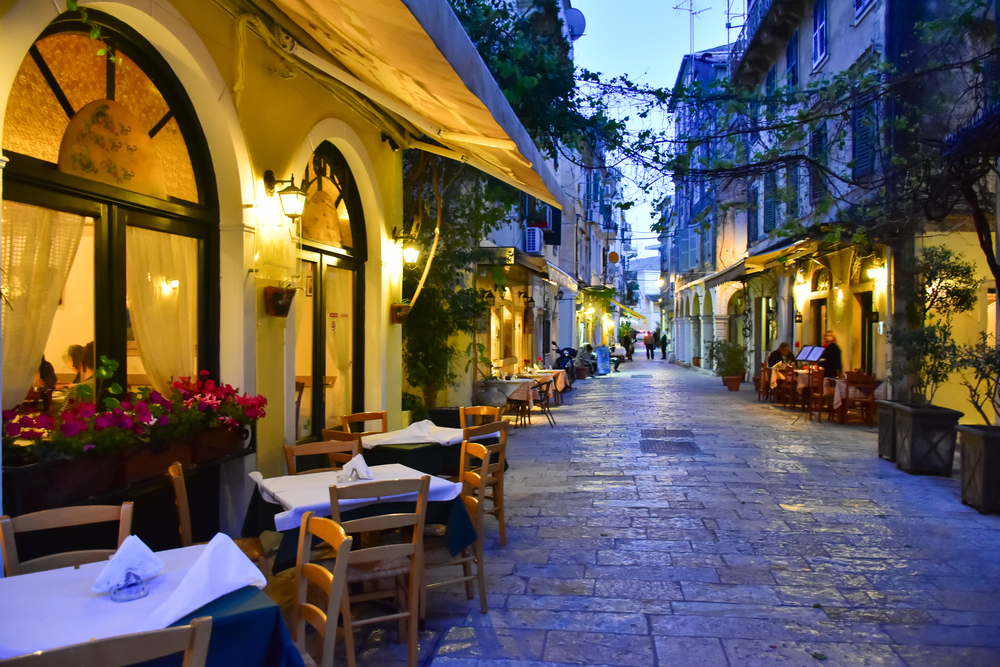 A romantic night in an alley where restaurants are seen with empty tables. 