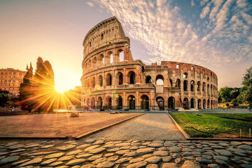 The Colosseum in Rome at sunset with cobblestone streets leading through one of the best tourist destinations in the world