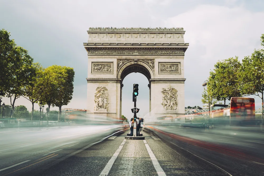 Champs-Elysees with blurred motion of cars passing the Arc de Triomphe to show why Paris is among the best tourist destinations