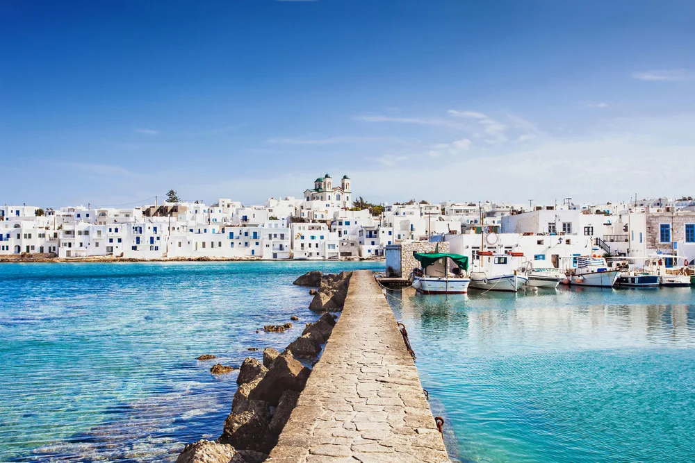 Low wall leading up to Naousa, Greece in Paros shows one of the top Greek party islands to visit for clubs and bars