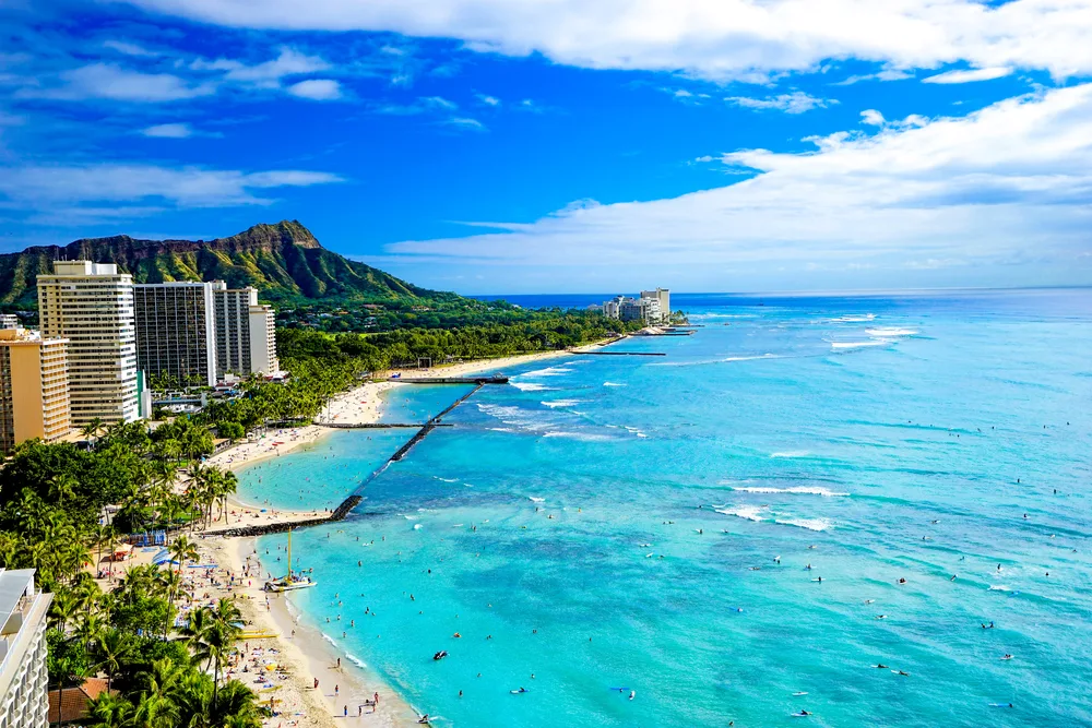 Aerial view of Waikiki Beach and Diamond Head crater in Honolulu, Hawaii as an example of what you'll see while traveling between islands in Hawaii