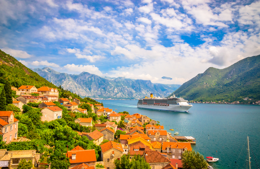 Gorgeous landscape of Perast in Montenegro with a cruise ship making its way through the valley for a guide titled Is the Mediterranean Safe to Visit