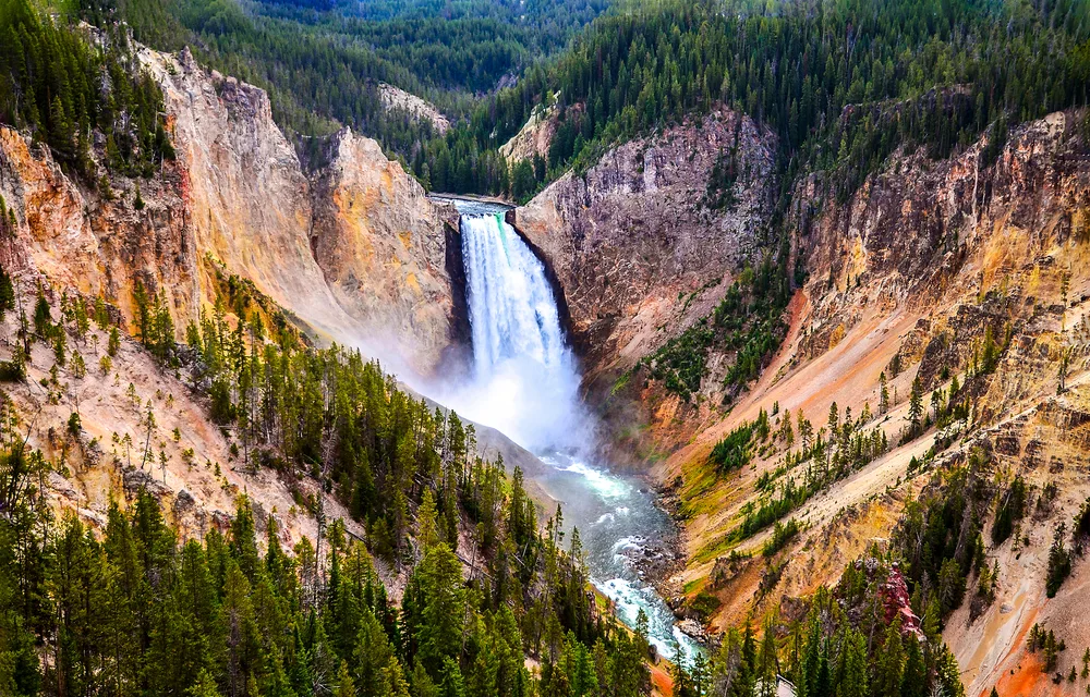 Aerial view of a rushing waterfall through the canyon at Yellowstone National Park highlights why this is one of the best tourism spots in the world