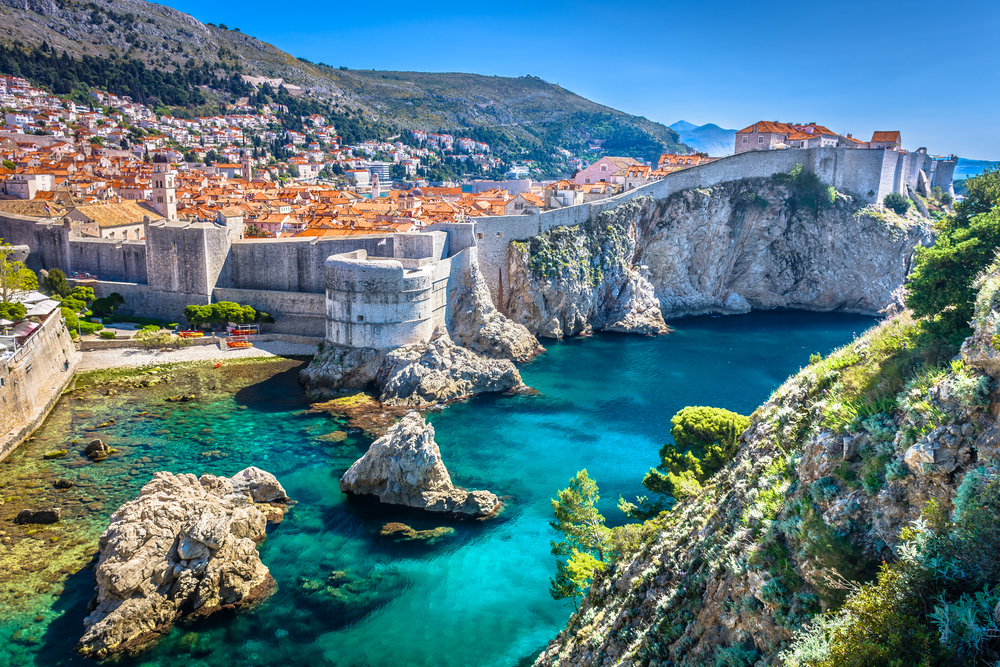 A medieval-looking city in Dubrovnik, one of the best areas to stay in Croatia, the cliff is fortified by stone walls that surrounds the city, and the bottom of the cliff are crystal clear waters with huge rocks.
