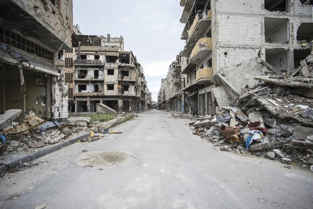 Destruction of buildings in Homs, Syria shown on an empty street to indicate the unsafe areas to avoid in Syria