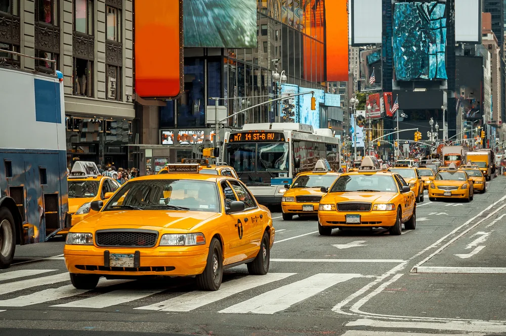 Yellow taxi cabs in NYC make their way down the street