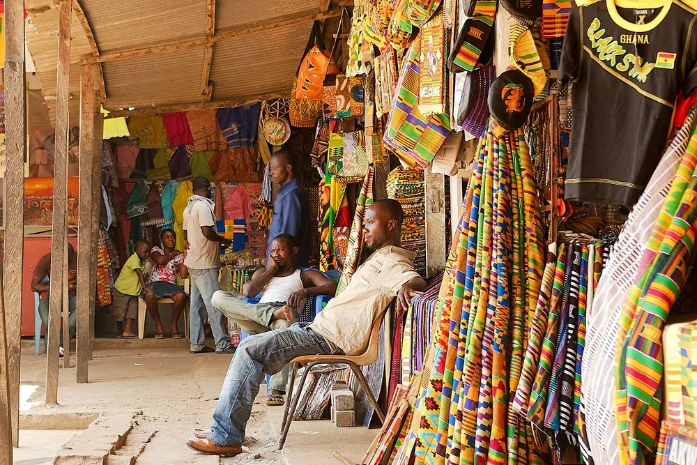 Man selling bracelets and clothing out of his open-air shop in Ghana