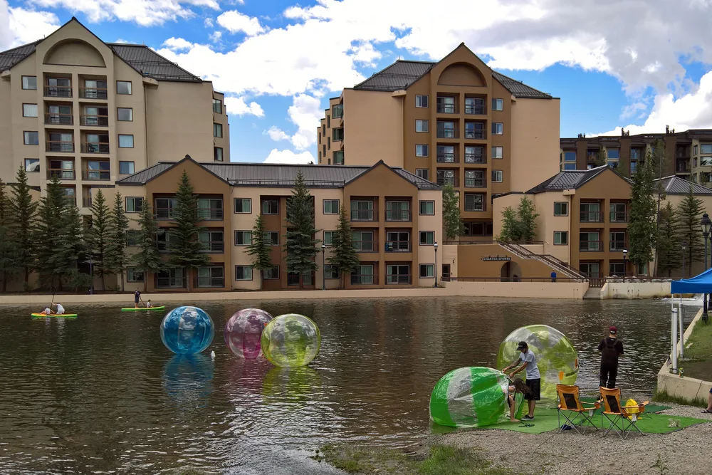 People in inflatable balls walking on the water in the late summer, one of the best times to travel to Breckenridge