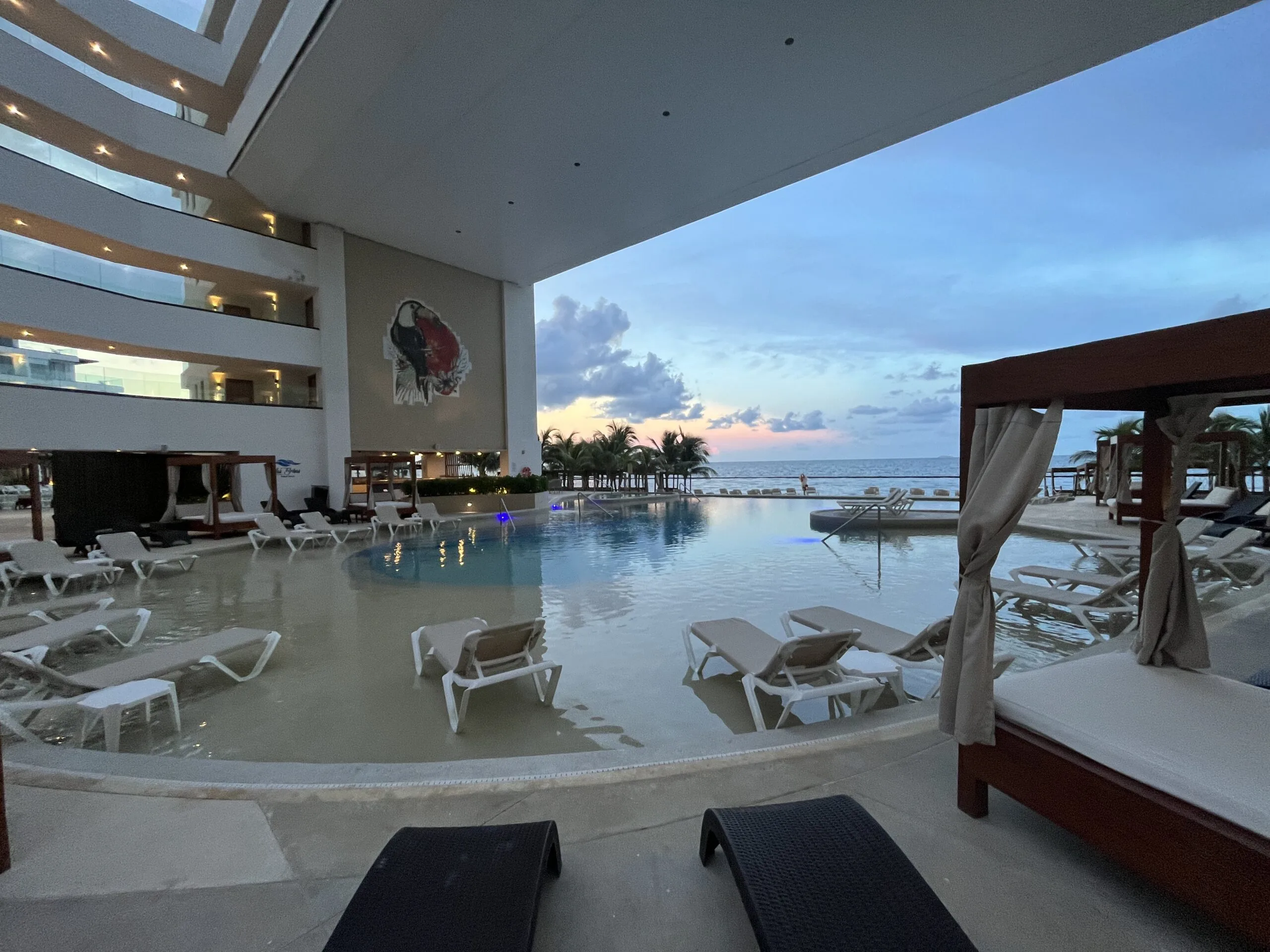The pool deck below the overhang with oceanfront rooms at Sensira resort in Riviera Maya