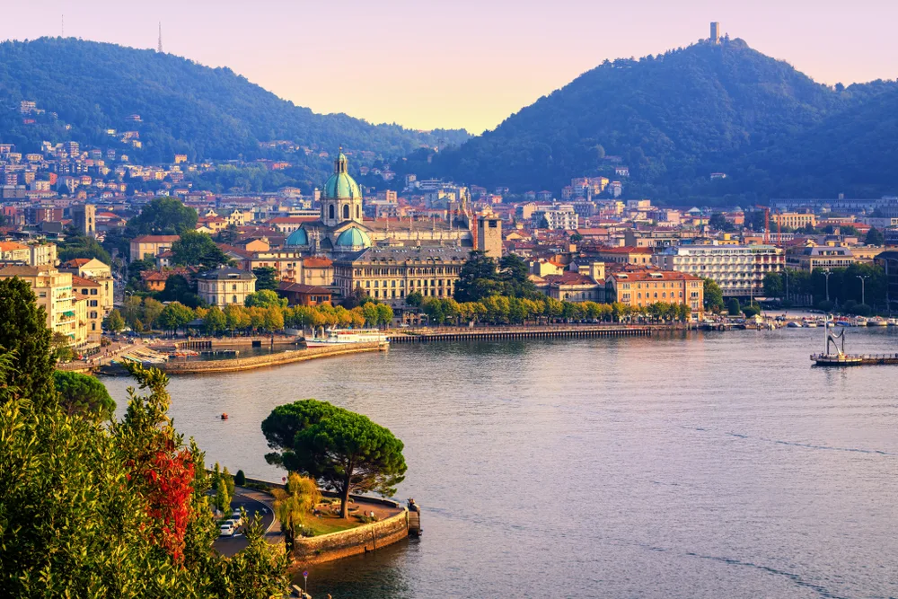 A city situated between lake and hills during sunset in Como, a top pick for where to stay in Lake Como