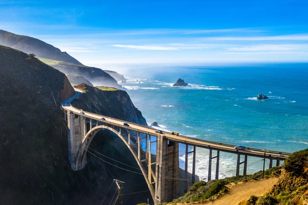 Aerial view of the famous Bixby Creek Bridge across the Pacific with dramatic rock formations and cliffs around one of the best weekend trips in the US, Big Sur 