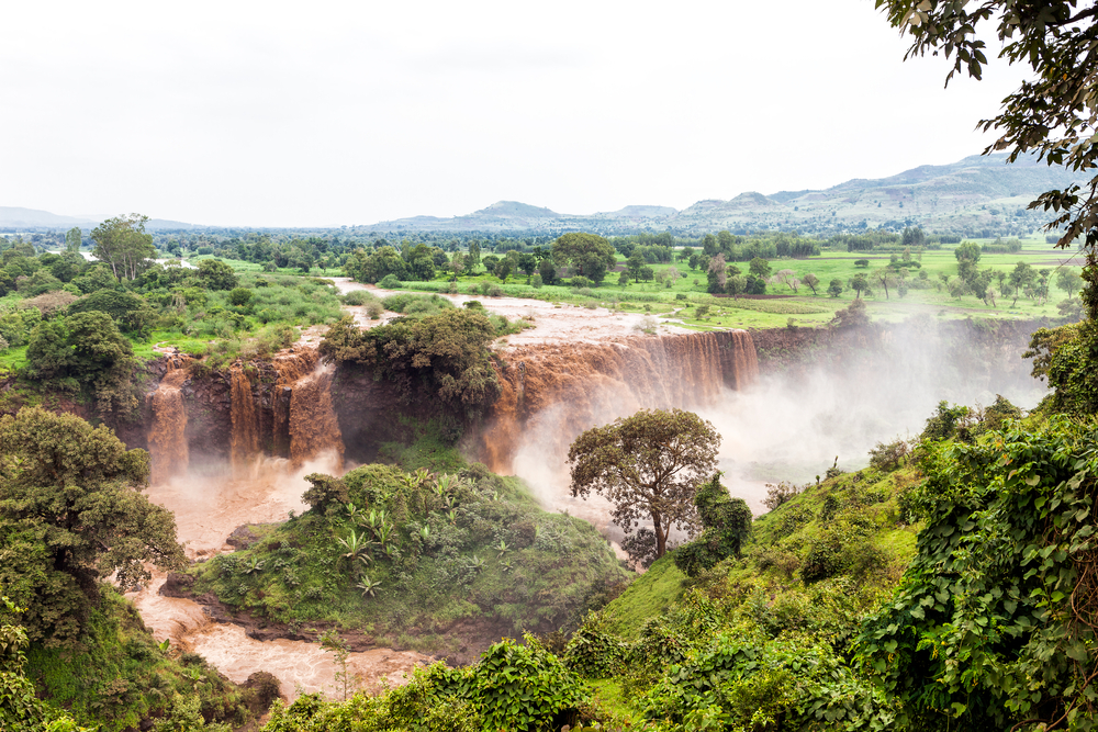 A muddy waterfalls in Bahir Dar, one of our picks on the best area to stay in Ethiopia, brownish water and mist is at the bottom of the falls.