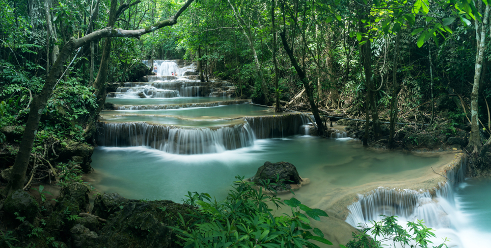 Haui Mae Khamin waterfall flowing through the rainforest in Khuean Srinagarindra National Park, Thailand for a guide showing how long a flight to Thailand takes