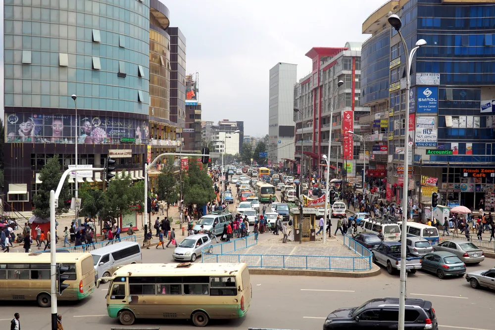 A busy afternoon at Addis Ababa, one of the best areas to stay in Ethiopia, cars are congested on the streets and a volume of people are walking on the sidewalk.