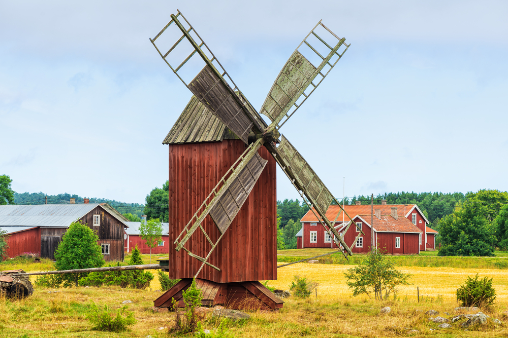 A native windmill and other old houses in background can be seen in a small country town. 