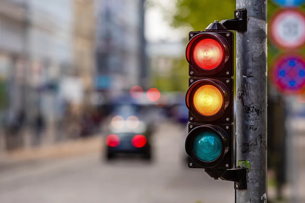 A traffic light in red light and orange light about to transition to go signal, an concept image for the guide about safety in visiting Slovenia.