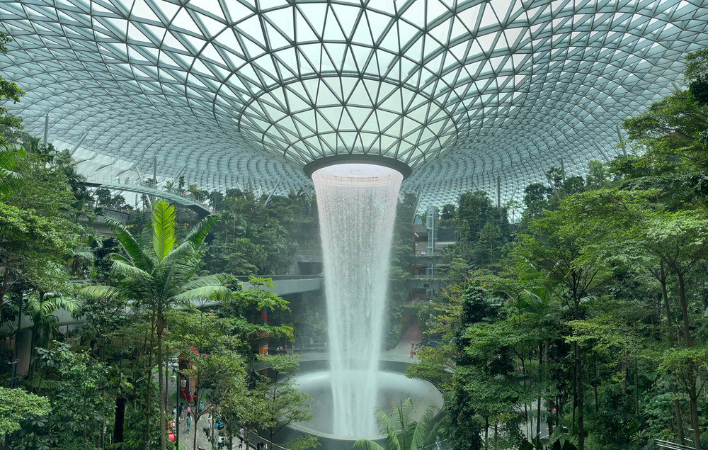 A famous Changi Jewel Airport where a large fountain structure drops water from the ceiling. 