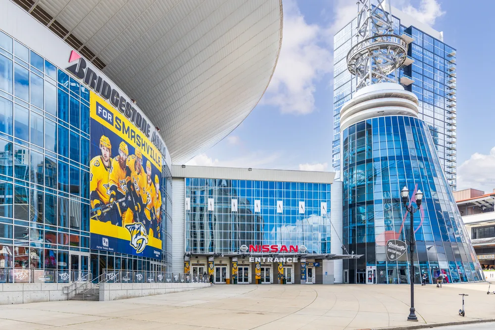 A glass building with a tower and huge image displaying a hockey team.